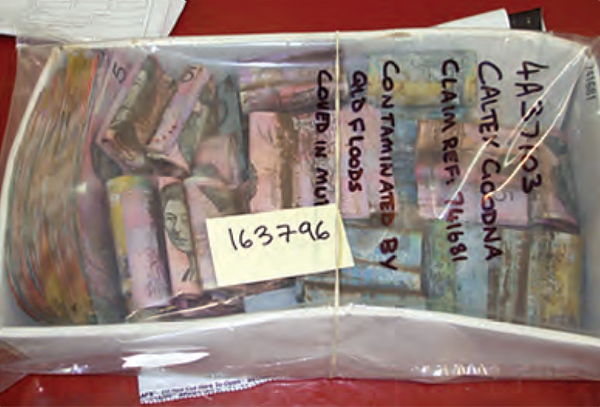 Hundreds of claims were received at the Damaged Notes Laboratory in Craigieburn after the Queensland floods early in 2011, including these banknotes covered in mud from Caltex in Goodna, west of Brisbane