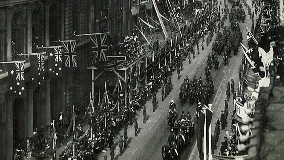 Photograph showing the procession passing along George Street.