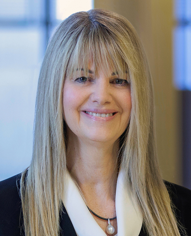 A headshot photograph of Michelle, looking directly at the camera and smiling. 